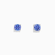 The Nahla Siri Sterling Silver Tanzanite Stud Earrings, 0.95 TCW, feature square-cut vibrant blue tanzanite gemstones set in simple prongs and are displayed against a plain white background.