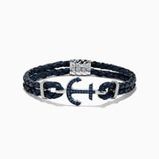 The Mens Sterling Silver Woven Leather Sapphire Anchor Bracelet, 0.52 TCW, features navy blue braided leather and a sterling silver anchor clasp set with sapphire gemstones.