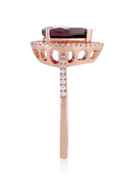 The Bordeaux 14K Rose Gold Rhodolite Garnet and Diamond Ring (1.46 TCW) features a pear-shaped rhodolite garnet center, surrounded by a halo of white diamonds with additional diamond accents on the band.