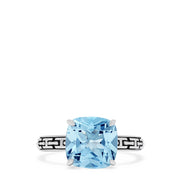 The 925 Sterling Silver Blue Topaz Ring, 5.20 TCW, features a square-cut light blue gemstone and geometric black engravings along the band, offering a modern and elegant style.