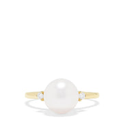 The 14K Yellow Gold Cultured Pearl and Diamond Accented Ring, 0.05 TCW, features a large round cultured pearl at the center with diamond accents on each side, shown on a plain white background.