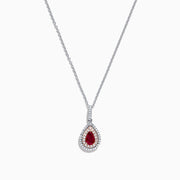 The Ruby Royale 14K Two Tone Gold Pear Shaped Ruby Pendant (0.68 TCW) features a stunning ruby, accented by small clear stones, showcased on a white background.