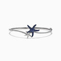 The Seaside 14K Gold Blue Sapphire & Diamond Starfish Bracelet, 1.06 TCW features two starfish—one adorned with blue sapphires, the other with diamond accents—plus sparkling clear stones along part of the bangle.
