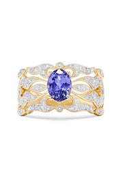 The 14K Yellow Gold Tanzanite and Diamond Ring, 1.45 TCW, showcases a large oval tanzanite center with shimmering white diamonds along the intricately designed openwork band.