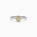 The Canare 18K Two-Tone Gold Yellow and White Diamond Ring, 0.79 TCW, showcases an oval yellow gemstone surrounded by a halo of clear diamonds and more diamonds on the band, beautifully displayed on a white background.