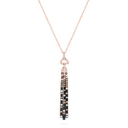 The Confetti 14K Gold Pendant features black, espresso, and white diamonds (1.17 TCW) on a long rose gold chain with a gold pendant accented by geometric details and three black tassels adorned with clear gemstones.