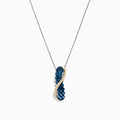 This 14K two tone gold necklace features a crossover pendant with blue and white diamonds (1.00 TCW) on one side, clear gemstones on the other, separated by a gold-toned wavy line.