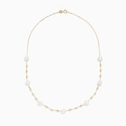 The 14K Yellow Gold 16 Pearl Station Necklace showcases evenly spaced white pearls and gold beads along a delicate chain.