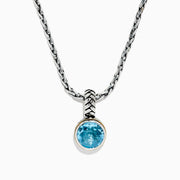A 925 sterling silver necklace with an 18K gold-accented, round blue topaz pendant (7.36 TCW) is displayed on a white background.
