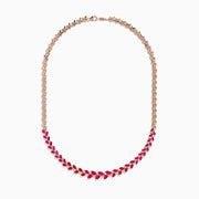 The Ruby Royale 14K Yellow Gold Ruby and Diamond Leaf Necklace showcases a leaf-inspired design with alternating rubies and diamonds in front, smoothly transitioning to a sleek yellow gold pattern at the back.