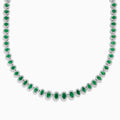 The 14K White Gold Emerald and Diamond Tennis Necklace showcases oval green emeralds, each surrounded by sparkling diamonds, evenly set along a white gold chain displayed on a white background.