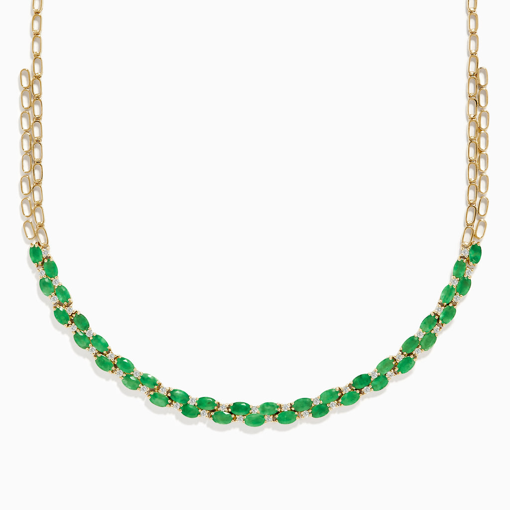 A beautiful 14K yellow gold necklace with two chains, featuring a row of oval emeralds and diamonds along the front for a timeless, elegant look.