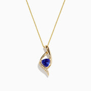The Nahla Siri 14K Gold Tanzanite and Diamond Pendant, 1.46 TCW, features a swirling gold design with a triangular blue tanzanite center and a row of diamonds along one edge, shown against a white background.