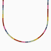 The Watercolors 14K Yellow Gold Multi Sapphire Tennis Necklace features small, round sapphires in a rainbow pattern, elegantly set in yellow gold and arranged in a smooth curve.