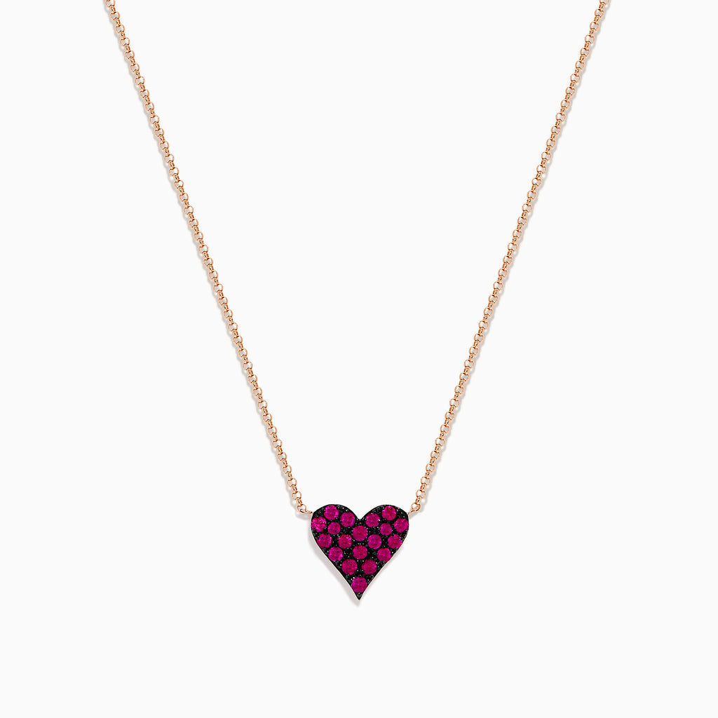 The 14K Rose Gold Ruby Pave Heart Necklace features a heart-shaped pendant encrusted with sparkling rubies on a delicate rose gold chain, displayed against a plain white background.