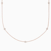 The Pave Rose 14K Rose Gold Diamond Station Necklace (0.62 TCW) features delicately bezel-set round diamonds, offering a minimal and elegant look against a plain white background.