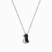 The Safari Sterling Silver Black and White Diamond Penguin Pendant (0.31 TCW) hangs from a delicate chain, its playful penguin design dazzling with black and white diamonds set in sterling silver against a white background.
