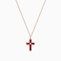 The Ruby Royale 14K Rose Gold Ruby and Diamond Cross Pendant, featuring a small clear center stone, is displayed on a rose gold chain against a white background.