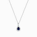 The Royale Bleu 14K White Gold Sapphire and Diamond Pendant features a teardrop sapphire encircled by shimmering diamonds, elegantly displayed on a white background.