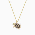 The Seaside 14K Gold Espresso & White Diamond Turtle Pendant (0.42 TCW) features a detailed jeweled shell, green eye, and turtle design on a chain necklace, with black, brown, and clear diamond accents.