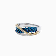 The 14K Two Tone Gold Blue and White Diamond Crossover Ring, 1.00 TCW, features a twisted silver design with yellow gold accents and sparkling rows of blue and white diamonds for a striking look.