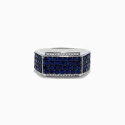The Mens 925 Sterling Silver Diamond and Blue Sapphire Ring features a wide band with a rectangular blue sapphire section bordered by small diamonds in a geometric pattern.