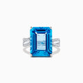 The Ocean Bleu 14K White Gold Blue Topaz and Diamond Ring, 13.65 TCW, showcases a large emerald-cut blue topaz with side baguette diamonds on a white gold band, set against a plain white background.