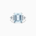The Aquarius 14K White Gold Aquamarine and Diamond Ring, 5.05 TCW, features a bold emerald-cut aquamarine center with rectangular and round diamond accents on each side, displayed against a plain white background.