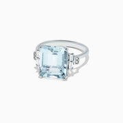 The Aquarius 14K White Gold Aquamarine and Diamond Ring, 5.05 TCW, features a bold emerald-cut aquamarine center with rectangular and round diamond accents on each side, displayed against a plain white background.