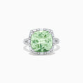 The 14K White Gold Green Amethyst and Diamond Ring showcases a cushion-cut green amethyst center, accented by a halo of clear baguette and round diamonds, all set in white gold.