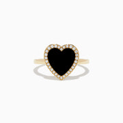 The 14K Yellow Gold Onyx and Diamond Heart Ring features a large heart-shaped onyx surrounded by sparkling diamonds, all set in yellow gold. Shown against a plain white background.