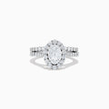 The 14K White Gold Diamond Ring and Matching Band Set, 2.00 TCW, features a large oval center diamond with a halo of round diamonds and a diamond-studded band—displayed against white, ideal for elegant bridal sets.