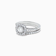 The Pave Classica 14K White Gold Diamond Engagement & Wedding Ring Set 1.34 TCW features a round center diamond, a sparkling diamond halo, and additional diamonds on the split band, shown against a white background.