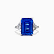 The 14K White Gold Tanzanite and Diamond Cocktail Ring, 7.83 TCW, features a large rectangular blue tanzanite with step-cut facets, accented by geometric clusters of sparkling diamonds on each side, showcased against a white background.