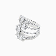 A Classique 14K White Gold Split Band Diamond Statement Ring with four emerald-cut clear stones and pavé diamonds forms stacked bands with intricate, sparkling details, showcased against a white background.