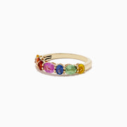 The Watercolors 14K Yellow Gold Multi Sapphire Ring, 2.00 TCW, showcases a vibrant row of oval sapphires in rainbow hues—yellow, orange, red, pink, blue, and green—elegantly set side by side across the band.
