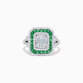 The Brasilica 14K White Gold Emerald and Diamond Ring showcases an emerald-cut diamond center, double square halos of diamonds and green emeralds, with additional diamonds on the split shank band, all set against a white background.