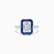 The Royale Bleu 14K White Gold Blue Sapphire and Diamond Deco Ring features a rectangular emerald-cut center, accented by blue sapphires and round diamonds along the band, all set against a white backdrop.