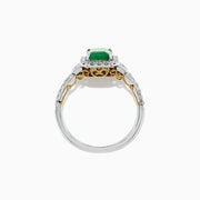 The Brasilica 14K Two Tone Gold Emerald and Diamond Ring, 1.90 TCW, features a striking rectangular emerald center, encircled by round diamonds and further accented with diamonds along the gold band.
