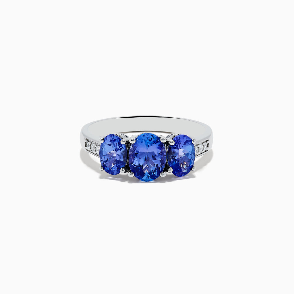 The Nahla Siri Sterling Silver Diamond and Tanzanite Ring features three oval-cut blue gemstones at the center, flanked by diamond accents on each side of the band, shown against a white background.