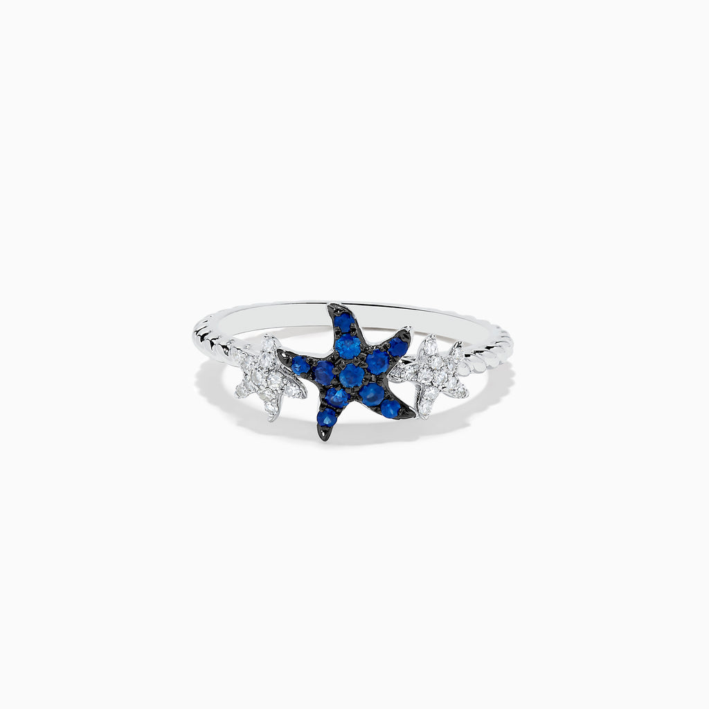 The Seaside 14K White Gold Sapphire and Diamond Starfish Ring showcases a blue sapphire and diamond starfish center, accented by two small clear gemstone fish shapes on each side, all set in white gold.