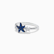 The Seaside 14K White Gold Sapphire and Diamond Starfish Ring showcases a blue sapphire and diamond starfish center, accented by two small clear gemstone fish shapes on each side, all set in white gold.