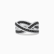 The 14K White Gold Black and White Diamond Crossover Ring features intertwining bands set with rows of black and white diamonds, creating a striking, braided design.