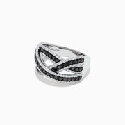 The 14K White Gold Black and White Diamond Crossover Ring features intertwining bands set with rows of black and white diamonds, creating a striking, braided design.