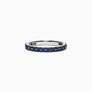 The Royale Bleu 14K White Gold Blue Sapphire Band Ring, 0.99 TCW, features a row of small round blue sapphires set all around a white gold band and is displayed on a plain white background.