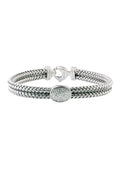 The 925 Sterling Silver and Diamond Bracelet, .15 TCW, features a woven design with a textured oval centerpiece adorned with diamonds and a secure clasp closure at the back.