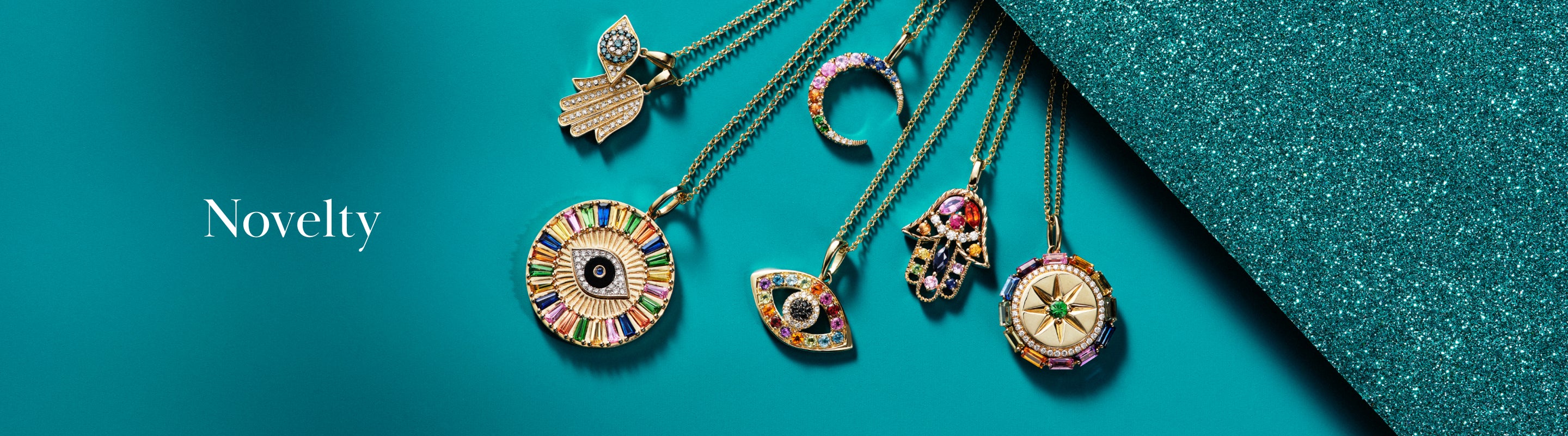 Six colorful, intricate gold pendants on chains are arranged fan-like on a teal background with glitter, next to the word “Novelty” in white text on the left.