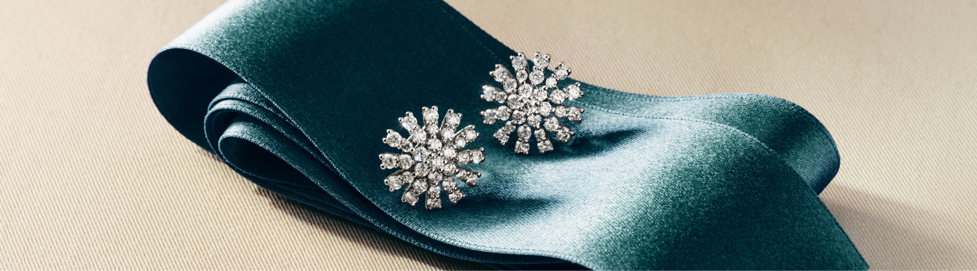 A person wearing gold rings and a bracelet touches their foot, with the words New Arrivals displayed on the left against a dark fabric background.