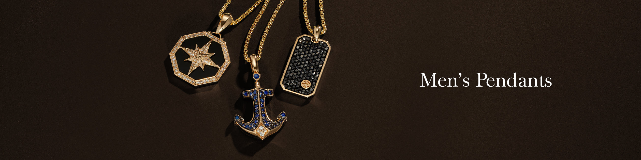 Three gold mens pendants on chains are displayed against a dark background: a star, a rectangular design, and a jeweled anchor. The text reads “Men’s Pendants.”.