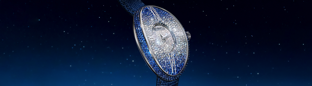 A luxurious, oval-shaped wristwatch encrusted with diamonds and blue gemstones is displayed against a dark, starry night sky background.